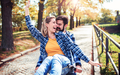 Fototapeta premium Couple in love. Romantic couple riding a bicycle in the park. Love, dating, romance