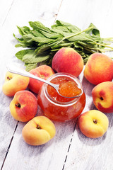 Peach vanilla jam with fresh peaches on table.