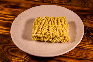 Ceramic plate with instant noodles on wooden table