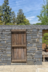 Wooden door inthe stone wall, Japanese garden, sunny day