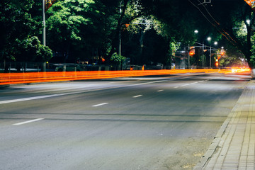Night cityscape. Blurred traces of car headlights, lights, dim streets.