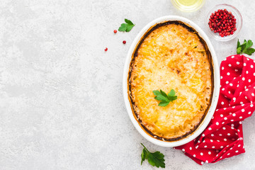 Loaded potato gratin in baking dish on concrete background.Top view, space for text.