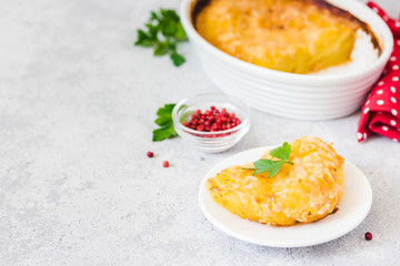 Crispy potato gratin in baking dish on concrete background. Selective focus, space for text.