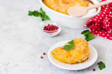 Scalloped potato gratin in baking dish on concrete background. Selective focus, space for text.
