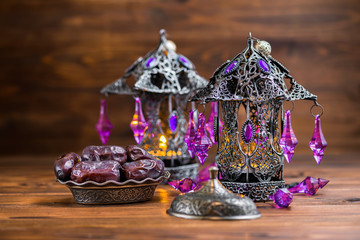 beautiful two Arab lamps with plate of dates on wooden background, concept Ramadan Kareem
