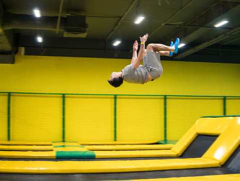 trampoline jumper performs complex acrobatic exercises and somersault on the trampoline.