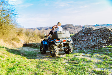 couple enjoys riding an ATV on forest hills