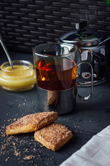 Glass cup of tea with biscuits and honey