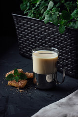 Glass cup of tea with biscuits and milk