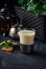 Glass cup of tea with biscuits and milk
