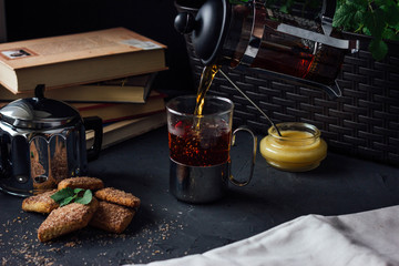 Glass cup of tea with biscuits and honey