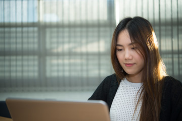 Fototapeta premium Beautiful asian woman working at the office in the evening,Thailand worker writing book in the company