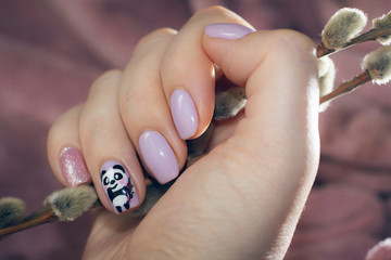 Fototapeta premium Manicure pastel color with a picture of a cute panda
