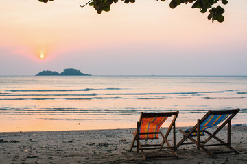 Couple of chairs on sunset beach.