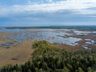 drone image. aerial view of rural area with fields and forests and swamp lake with blue water