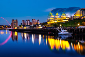 Famous Millennium bridge at night. Illuminated landmarks with river Tyne in Newcastle, UK
