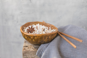 Fototapeta premium Bowl with wild brown mixed rice on the wooden background, wabi sabi style