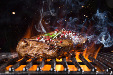 Beef steak on the grill with flames