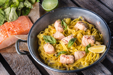 Pieces of salmon with pasta tagliatelle lemon and basil