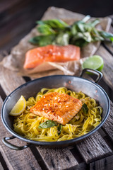 Pieces of roasted salmon with pasta tagliatelle lemon and basil