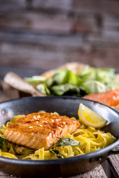 Pieces of roasted salmon with pasta tagliatelle lemon and basil