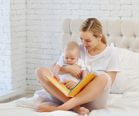 Family portrait of moms reading a book to a child in bed. The concept of family.