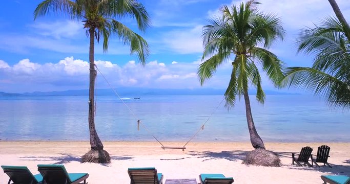 Fly cam slowly move through palm to open sea view,nature of  Thailand island sand beach
