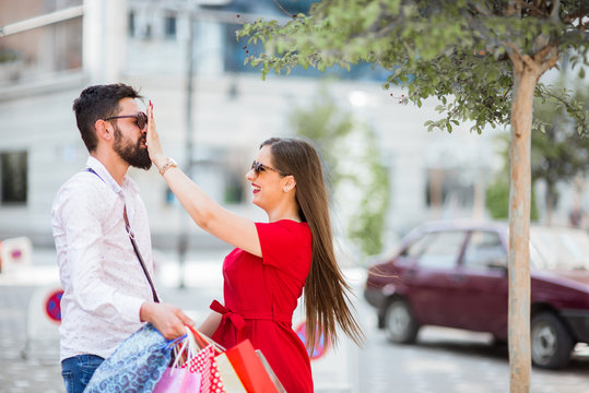 Portrait of cheerful couple with shopping bags