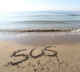 SOS on the sand of the beach