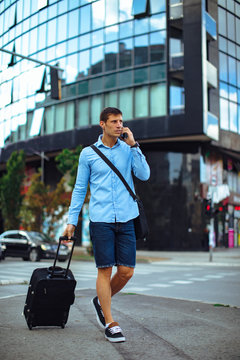 Young modern businessman on travel  talking on the phone in the downtown