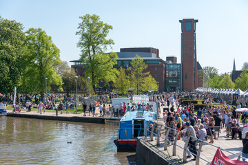 large crowd of people gather in front of the RSC by the canal basin and river 