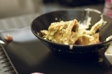 Mexican spicy nachos food on a black bowl