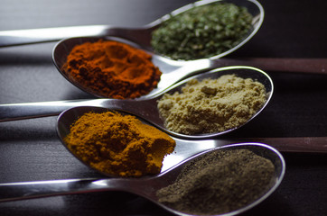 Spices colored in silver spoons