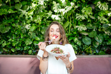 Woman eating salad at the vegetarian restaurant