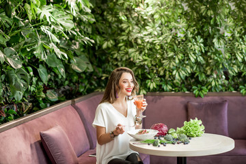 Woman with healthy food on the green wall background