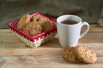 Oatmeal cookies with sunflower seeds near cup of tea.