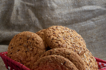 Savory cookies sprinkled with sesame seeds, sunflower on table and burlap background