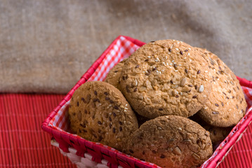 Savory cookies sprinkled with sesame seeds, sunflower on table and burlap background