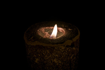 a burning candle in the dark