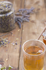 Floral fragrant tea in a glass. Lavender. Natural product. Health and detox. Wooden background and place for text.