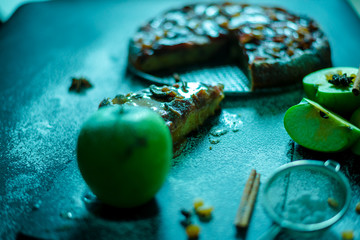 Apple pie with caramel cream on black table