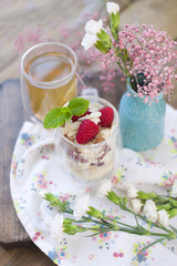 Green tea and muesli with berries and yogurt for breakfast. Healthy food. Vegetarian and vitamins. A bouquet of flowers in a vase. Text. Vertical photo