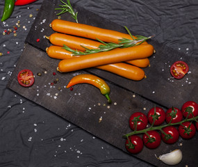 Wiener Sausages on black background. Top view with copy space.