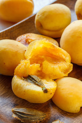 Whole and cut apricots on a wooden platter