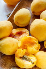 Whole and cut apricots on a wooden platter