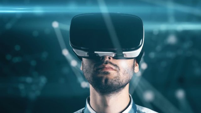 A young man with a beard in glasses of virtual reality on a technological background