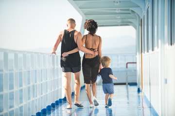Young beautiful happy family son mom and dad enjoying cruise on boat.