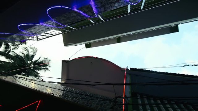 Young ninja man training parkour jump on roofs houses bottom view