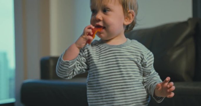 Little boy eating a red pepper