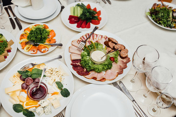 Served dishes to the table for holiday. Cutlery and food on whit